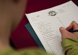 A child writes words on a worksheet at the Colorado State Spelling Bee