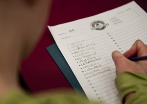 A child writes words on a worksheet at the Colorado State Spelling Bee