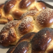 A close up of three loaves of baked challah