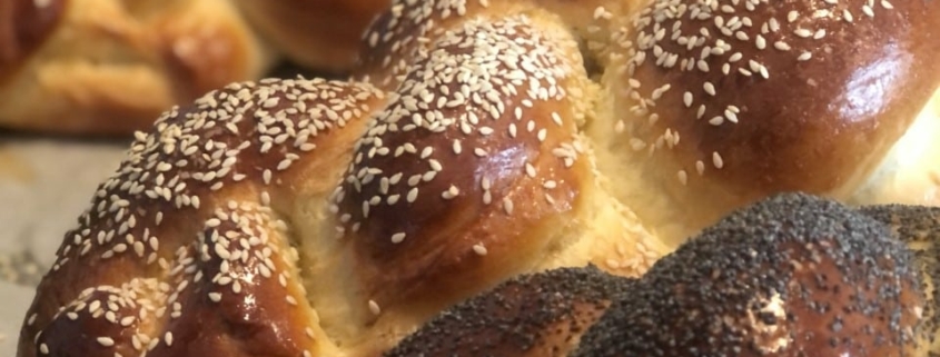 A close up of three loaves of baked challah