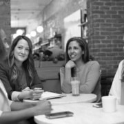 A group of women are seated at a table in discussion