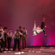 A student performs a backflip while performing in Central High School's production of Newsies during the Bobby G Awards