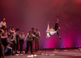 A student performs a backflip while performing in Central High School's production of Newsies during the Bobby G Awards