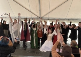 A large number of students clasp hands as they take a bow after performing in the DPS Shakespeare Festival