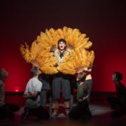 Ethan Hoover stands framed by classic, feathered fans while performing in Lakewood High School's production of Something Rotten during the Bobby G Awards