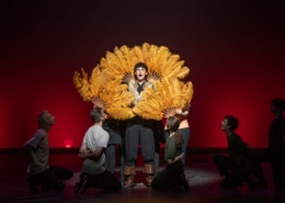 Ethan Hoover stands framed by classic, feathered fans while performing in Lakewood High School's production of Something Rotten during the Bobby G Awards