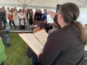 A teacher points to their students as they perform onstage during the DPS Shakespeare Festival