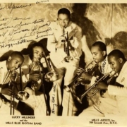 The Lucky Millinders pose for a photo with their instruments. The photo is autographed.