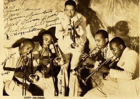 The Lucky Millinders pose for a photo with their instruments. The photo is autographed.