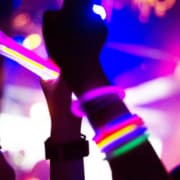 Hands covered with glow stick bracelets. They are having fun with taking pictures with mobile phone.