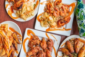 Colorful plates of saucy chicken, shrimp, and rice