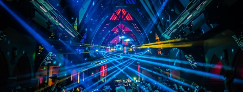 A neon light show in the Church Nightclub. The dance floor is packed