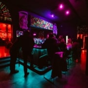 Interior of The Crypt. People are sitting at a neon bar