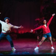 Shepherd Boy and Little Red pose during a dance number in Little Red. Their legs are apart and their arms are stretched wide.