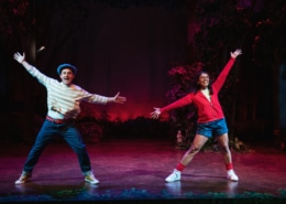 Shepherd Boy and Little Red pose during a dance number in Little Red. Their legs are apart and their arms are stretched wide.