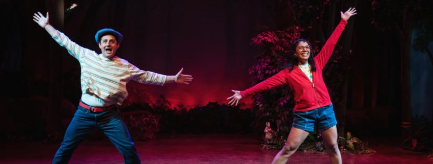 Shepherd Boy and Little Red pose during a dance number in Little Red. Their legs are apart and their arms are stretched wide.