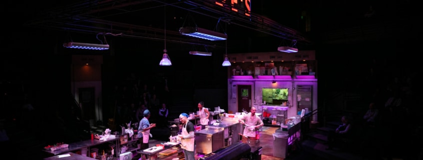 Clyde's glows in large lettering above the kitchen set. Four cooks are scattered about, prepping the kitchen.