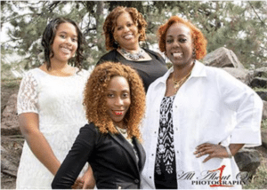 A group of women pose together for a photograph. They're all wearing black and white.