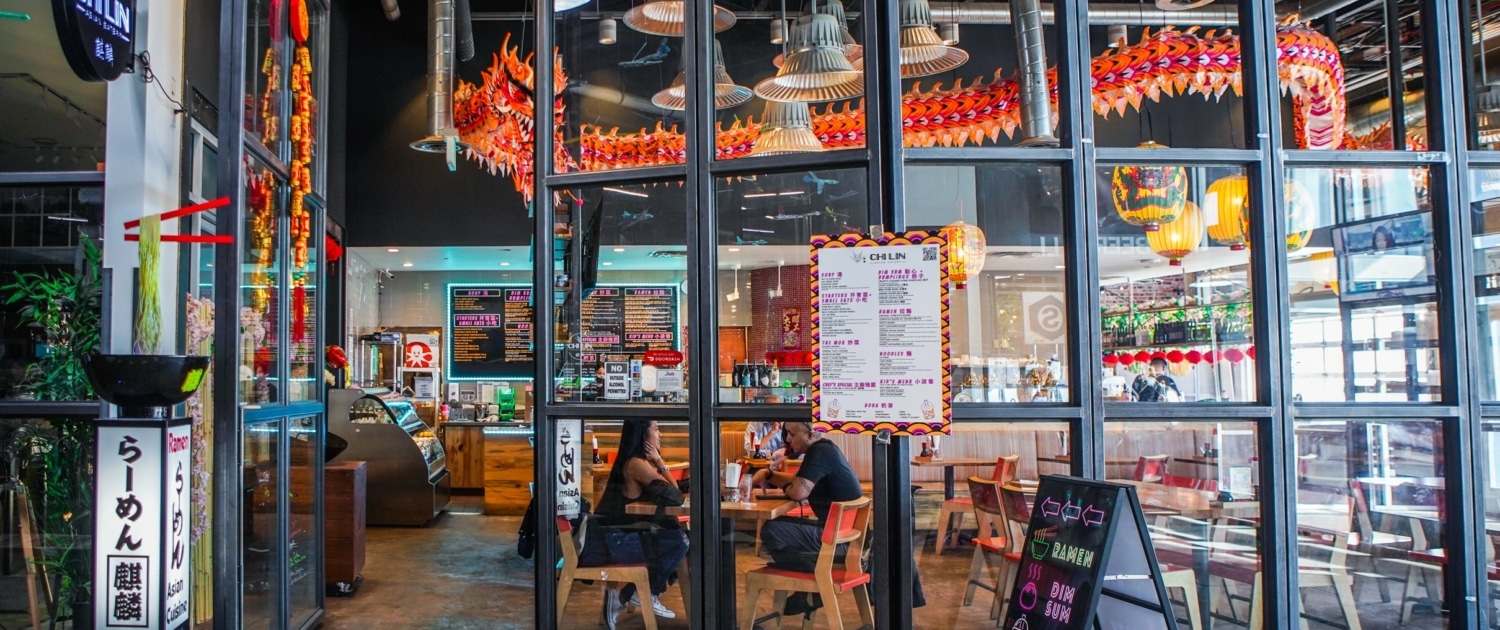 The exterior of Chi Lin at Stanley Marketplace. Through the windows, a long paper dragon is seen hanging from the ceiling.