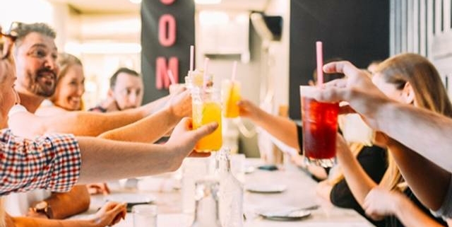 A group of friends toast with colorful beverages at Comida in Stanley Marketplace