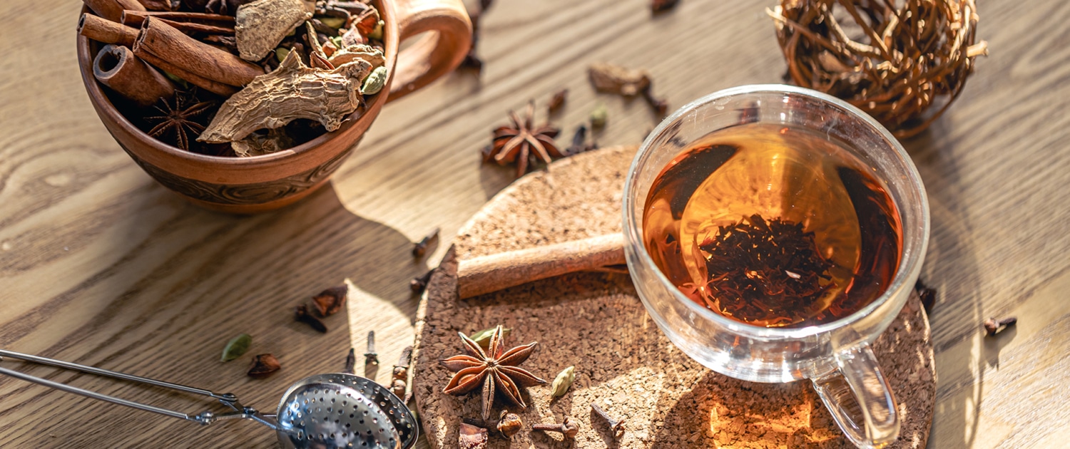A cup of tea surrounded by a sprinkle of exotic spices