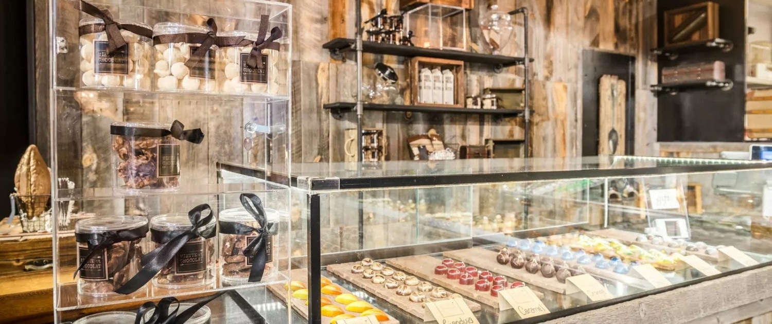 The pastry counter at Miette et Chocolat at Stanley Marketplace. On the left there is a shelf filled with chocolate boxes.