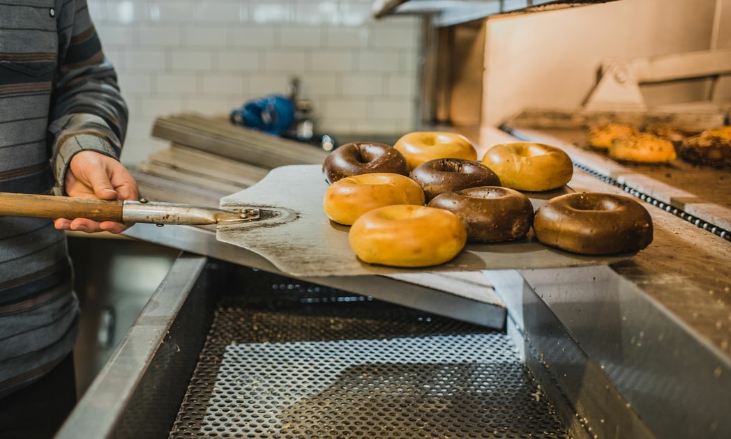 Bagels are removed from the oven at Rosenberg's in Stanley Marketplace.