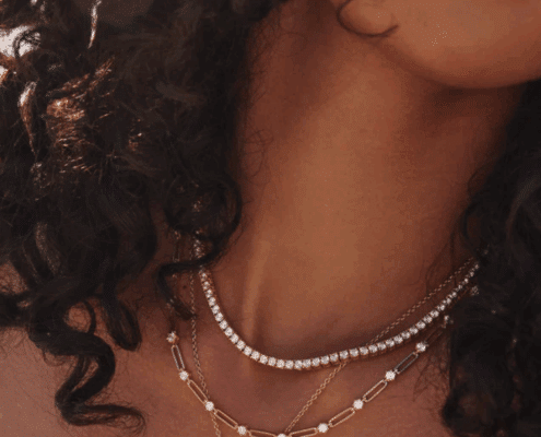 Woman with c urly hair wearing three necklaces