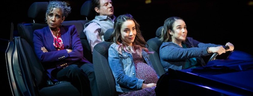 Three sisters ride in a car together. Celia drives while Tere sits annoyed in the backseat with the dead body.