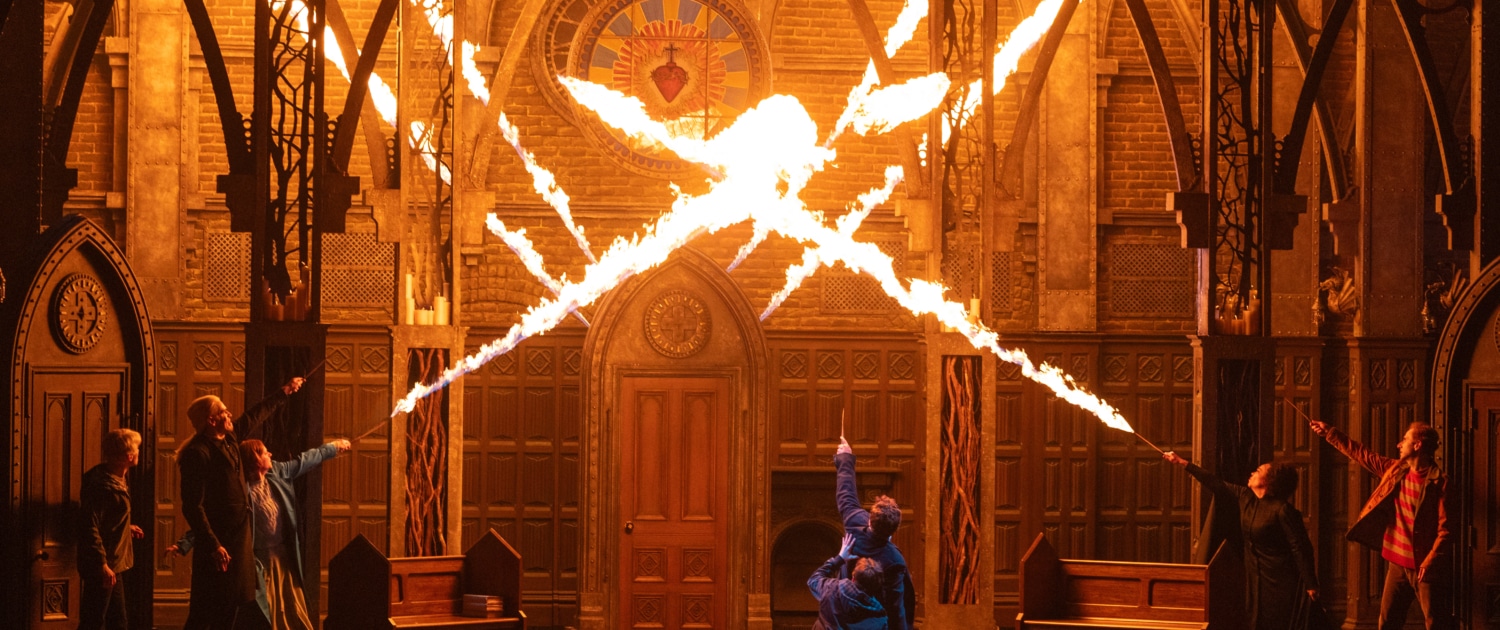 A stage production with bursts of fire filling what appears to be a cathedral