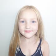 Headshot of young actress with long blonde hair and black, sleeveless tank top.