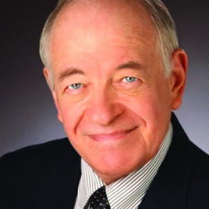 Headshot of actor Kenneth Tigar in black jacket, striped shirt, and black tie