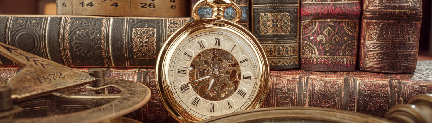 Vintage pocket watch with Roman numerals surrounded by antique books, an old calendar, and historical instruments—timeless heritage and history concept.