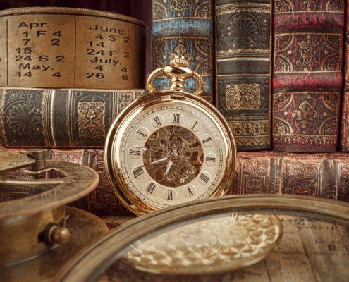 Vintage pocket watch with Roman numerals surrounded by antique books, an old calendar, and historical instruments—timeless heritage and history concept.