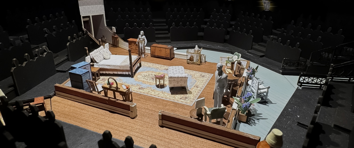 A set model of Cat on a Hot Tin Roof showing a bedroom in a Southern plantation with a bed, vanity, chaise lounge, rug, various chairs, and openings into a hallway and onto a veranda.