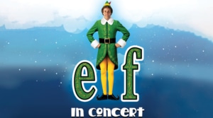 Promotional image for 'Elf in Concert' featuring Buddy the Elf standing with hands on hips against a snowy backdrop."