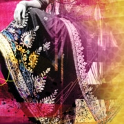 Close-up of a person’s crossed legs wearing a richly embroidered garment with floral patterns in white, blue, and yellow, set against a vibrant pink and yellow abstract background.