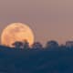 Full moon rising from behind a hill in the Diablo Mountain Range, in South San Francisco Bay Area, San Jose, California