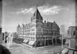 A black and white image of the historic Tabor Grand Opera House in Denver Colorado, which was five-stories, covered a square city block and had a rounded peak at one corner.