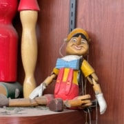 Classic pinocchio marionette puppet with blue bowtie, white collar, yellow shirt and red suspenders