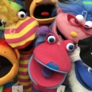 Assortment of colorful sock puppets in bright pink, red, blue, yellow and orange