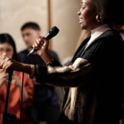 A woman standing at a podium holding a microphone while speaking to an audience