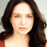 Person with long wavy hair against a light neutral background