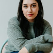 Person seated in a chair wearing a textured knit sweater