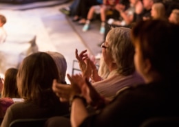 Audience clapping with performer on stage