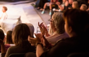 Audience clapping with performer on stage