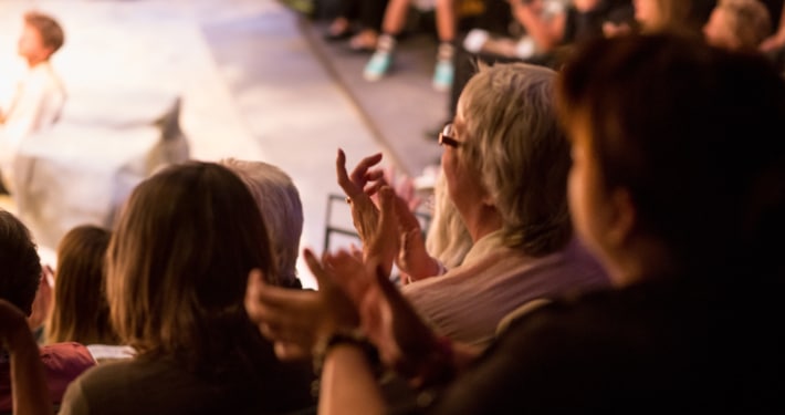 Audience clapping with performer on stage