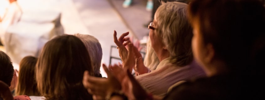 Audience clapping with performer on stage