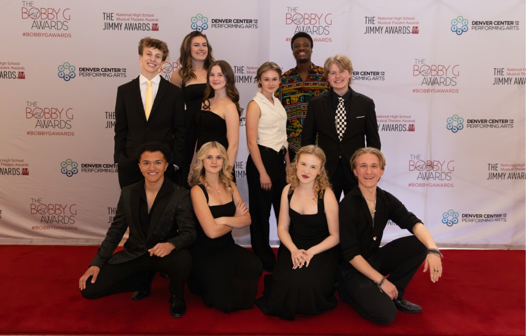 A group of ten performers dressed in formal black attire pose together on a red carpet in front of a Bobby G Awards and Denver Center for the Performing Arts step-and-repeat backdrop.