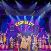 Full cast of Spamalot musical performing Camelot number on colorful stage with dancers and knights”